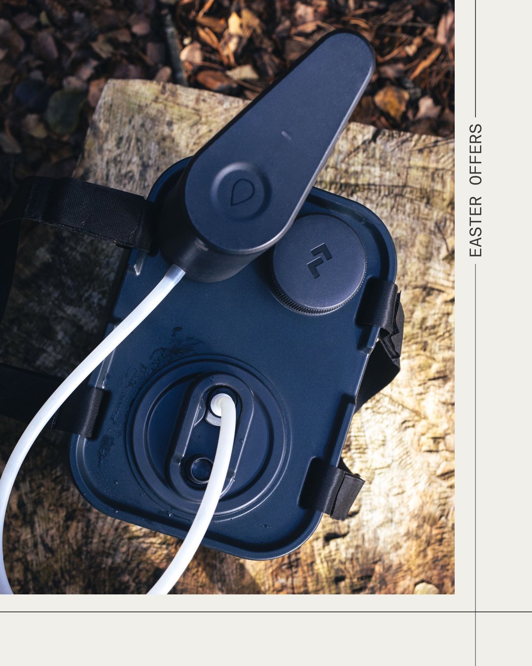 Bovenaanzicht van een Dometic watercontainer met aangesloten drinkslang op een houten ondergrond, ideaal als duurzaam hydratatiesysteem voor kamperen.