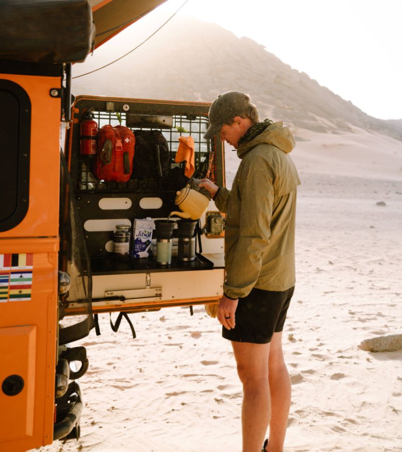 Male pouring a coffee in the back of car