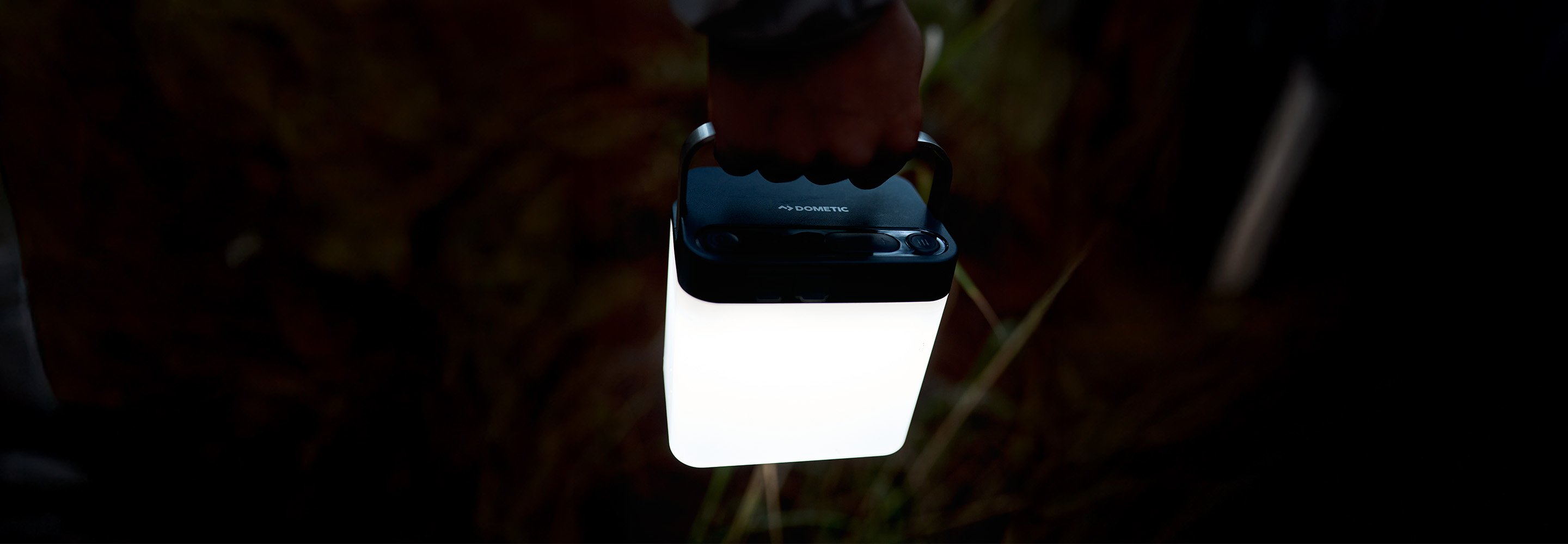 Dometic GO Area Camp Light buren i hand på kvällen, portabel utomhuslampa för belysning vid camping och overlandresor