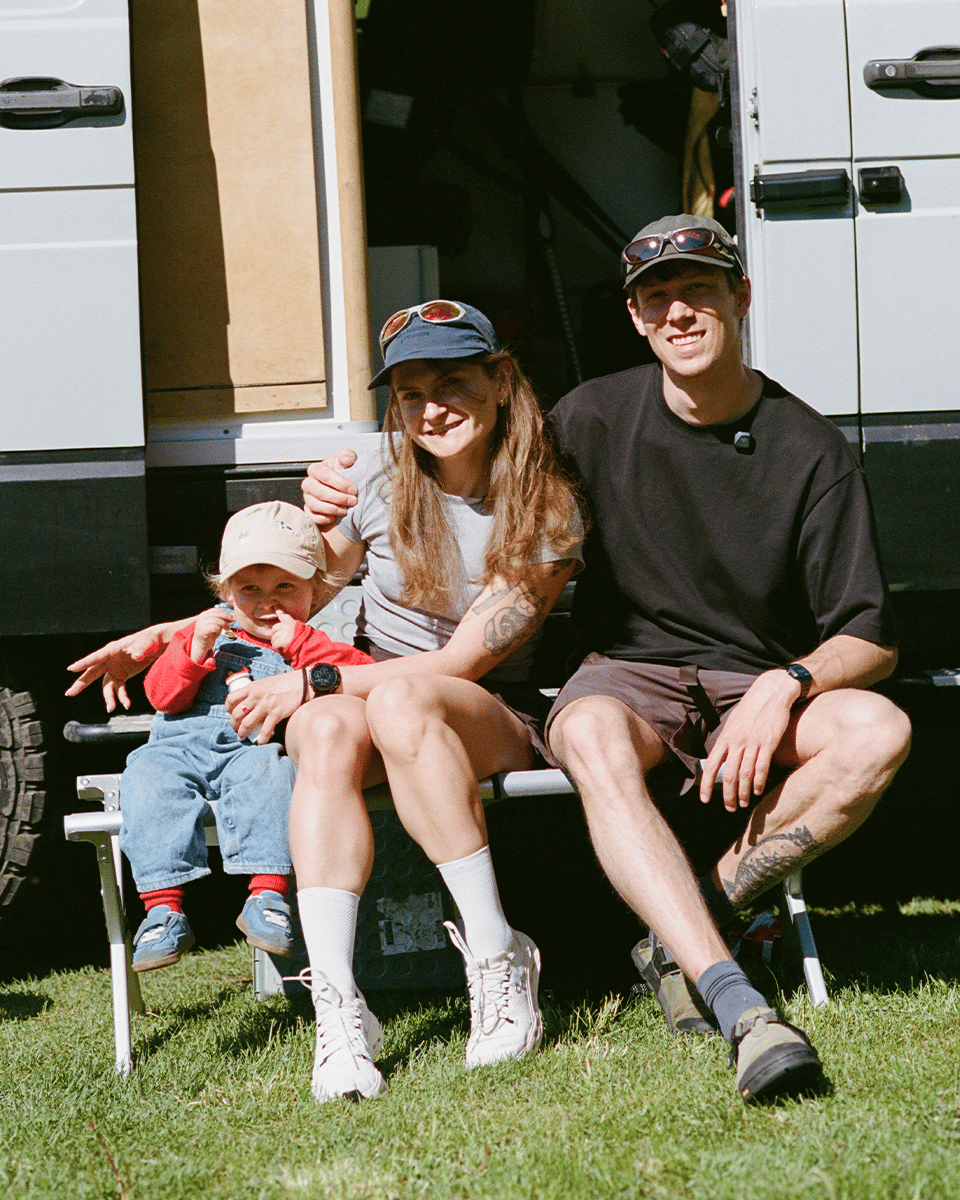 A family siitting outside their campervan