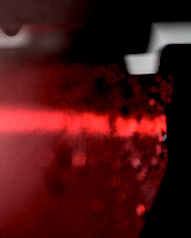 Abstract close-up of illuminated red vehicle light with water droplets