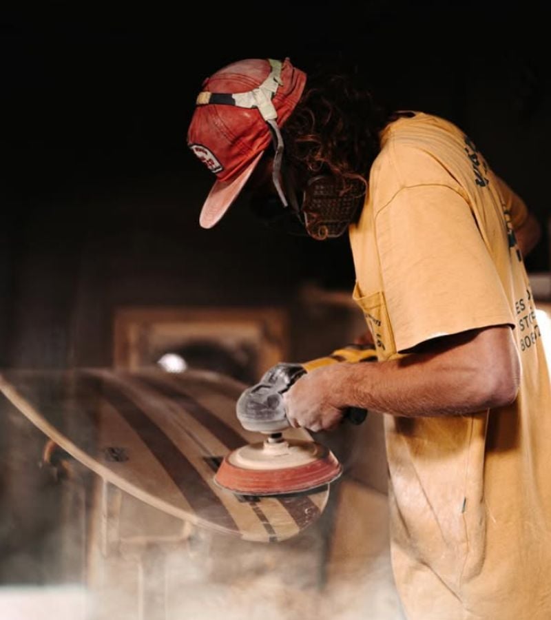 A man shaping a surfboard