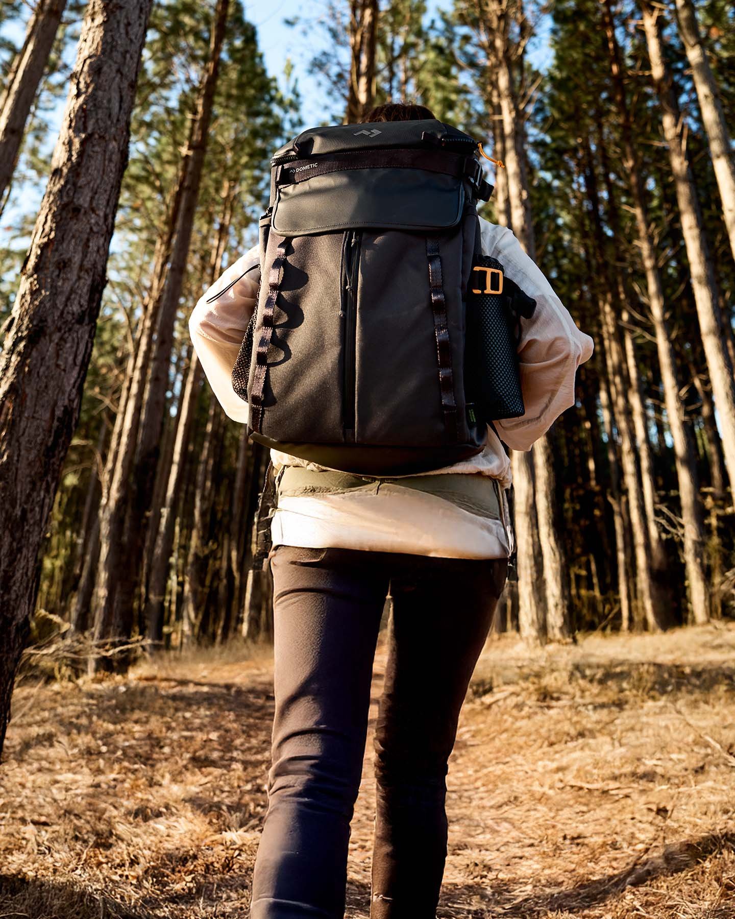 Person wearing large outdoor backpack in forest, durable gear pack for hiking and outdoor adventures