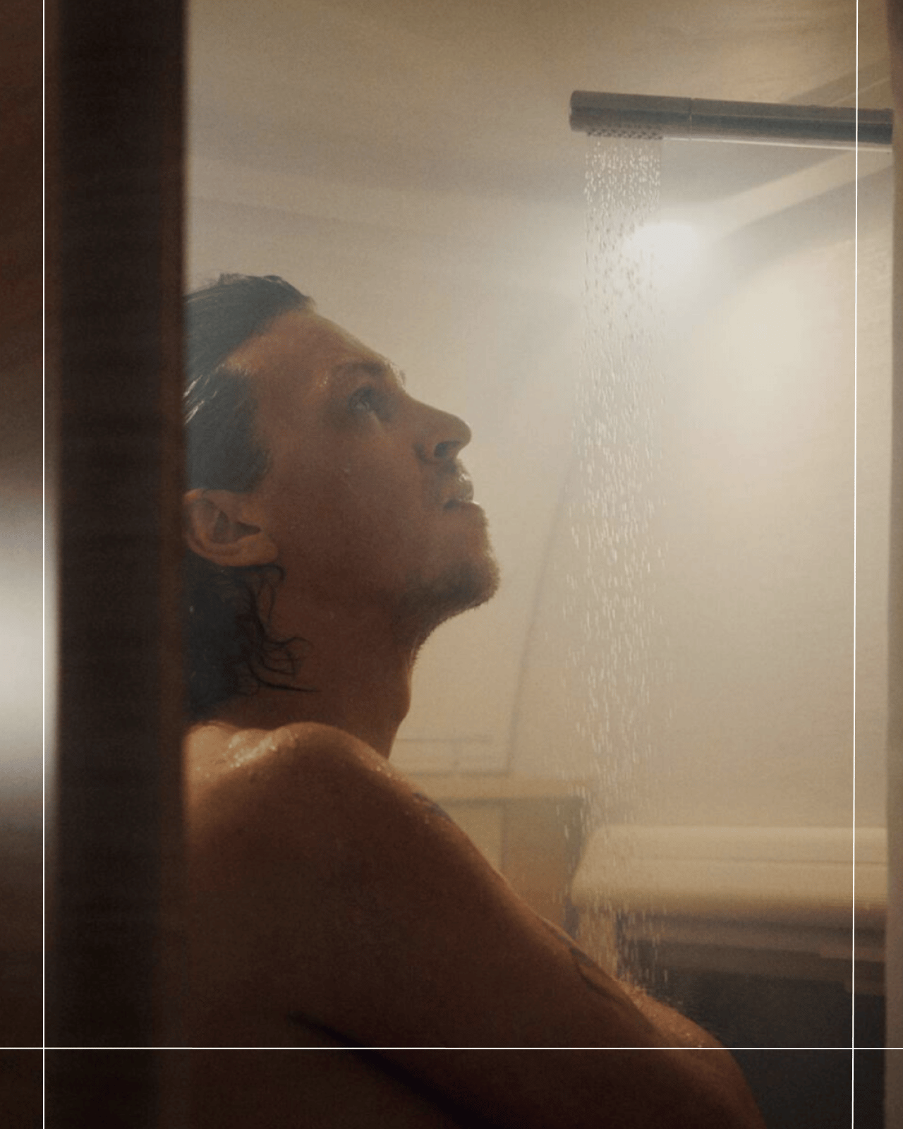 Persona duchándose con agua caliente en el baño de una autocaravana, destacando la comodidad a bordo y el agua caliente durante el viaje