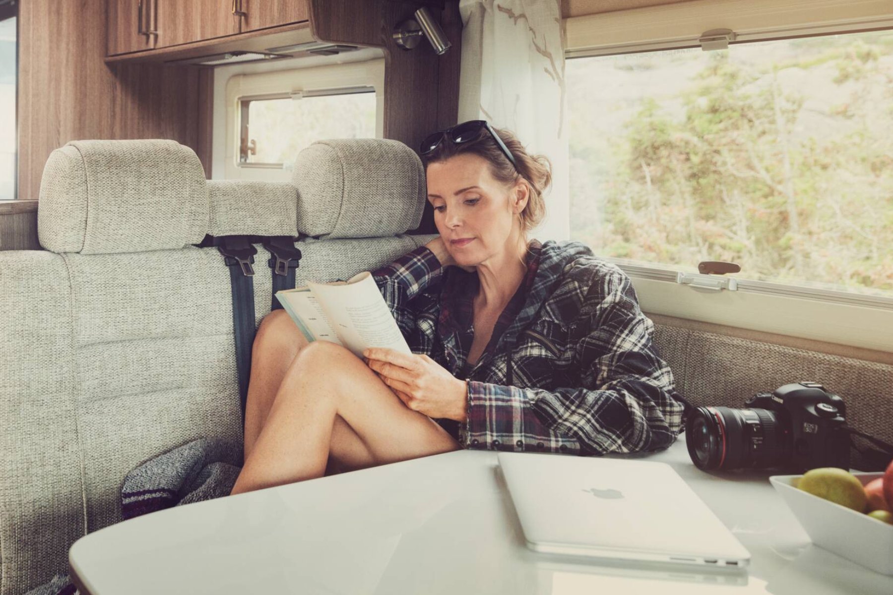 Woman reading a manual, seated inside an RV.