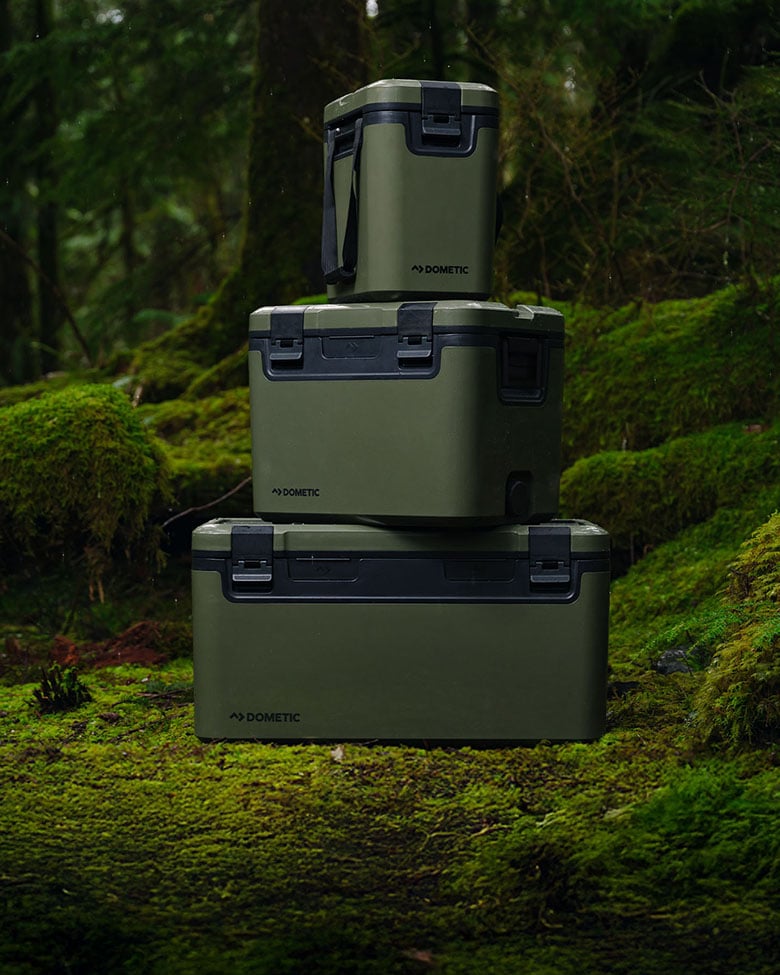 Dometic Recon passive coolers in Lichen color stacked in forest, durable ice chests for outdoor camping and adventure travel
