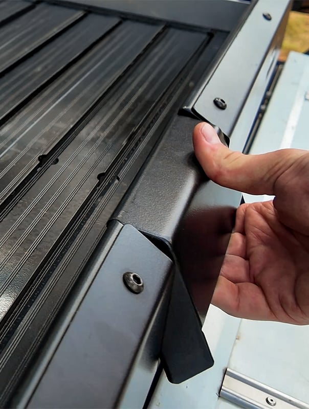 Hand trying to open the cargo bed slide latch