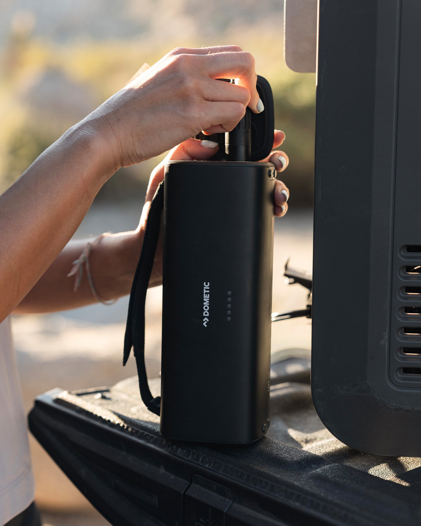 Batería de litio portátil Dometic PLB15 colocada sobre un vehículo, solución de energía compacta para uso outdoor