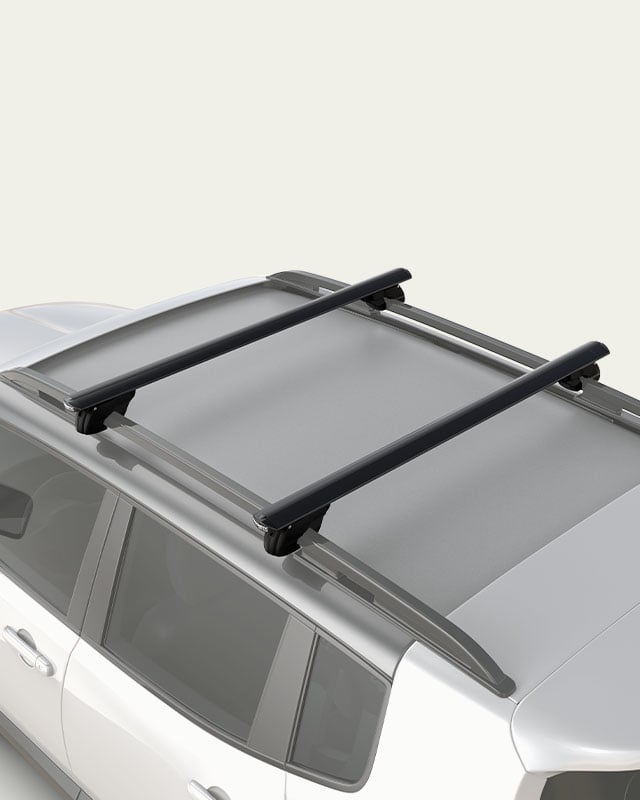 Cross Bars mounted on raised roof rails, providing a versatile load-carrying solution for sports equipment, cargo and roof-mounted accessories
