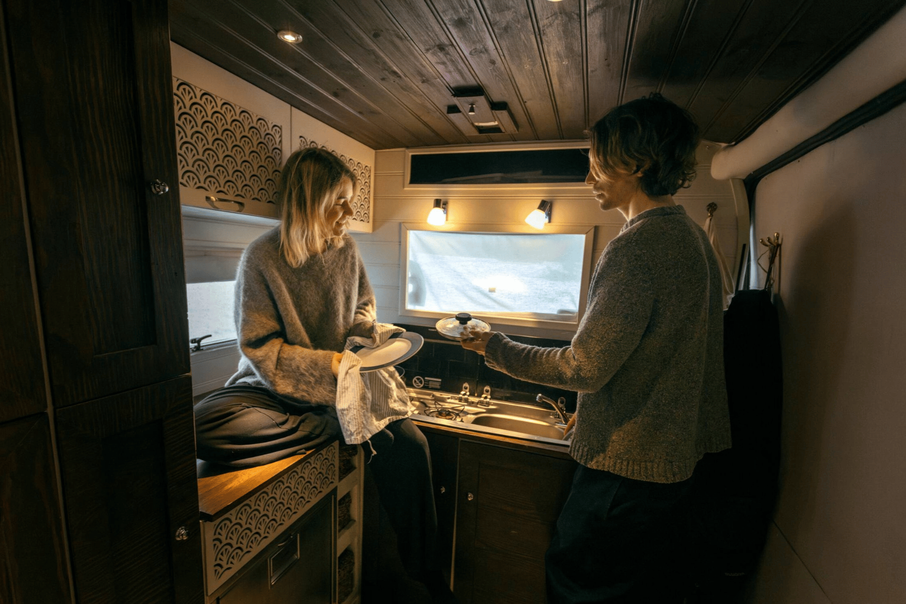 Woman and man inside RV kitchen.