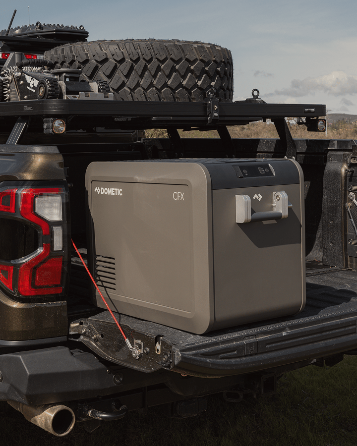 Pickup truck with a bed rack system carrying a Dometic CFX powered cooler.