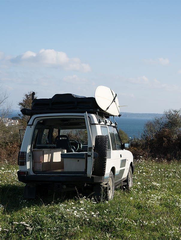Car parked on the grass with an ocean view