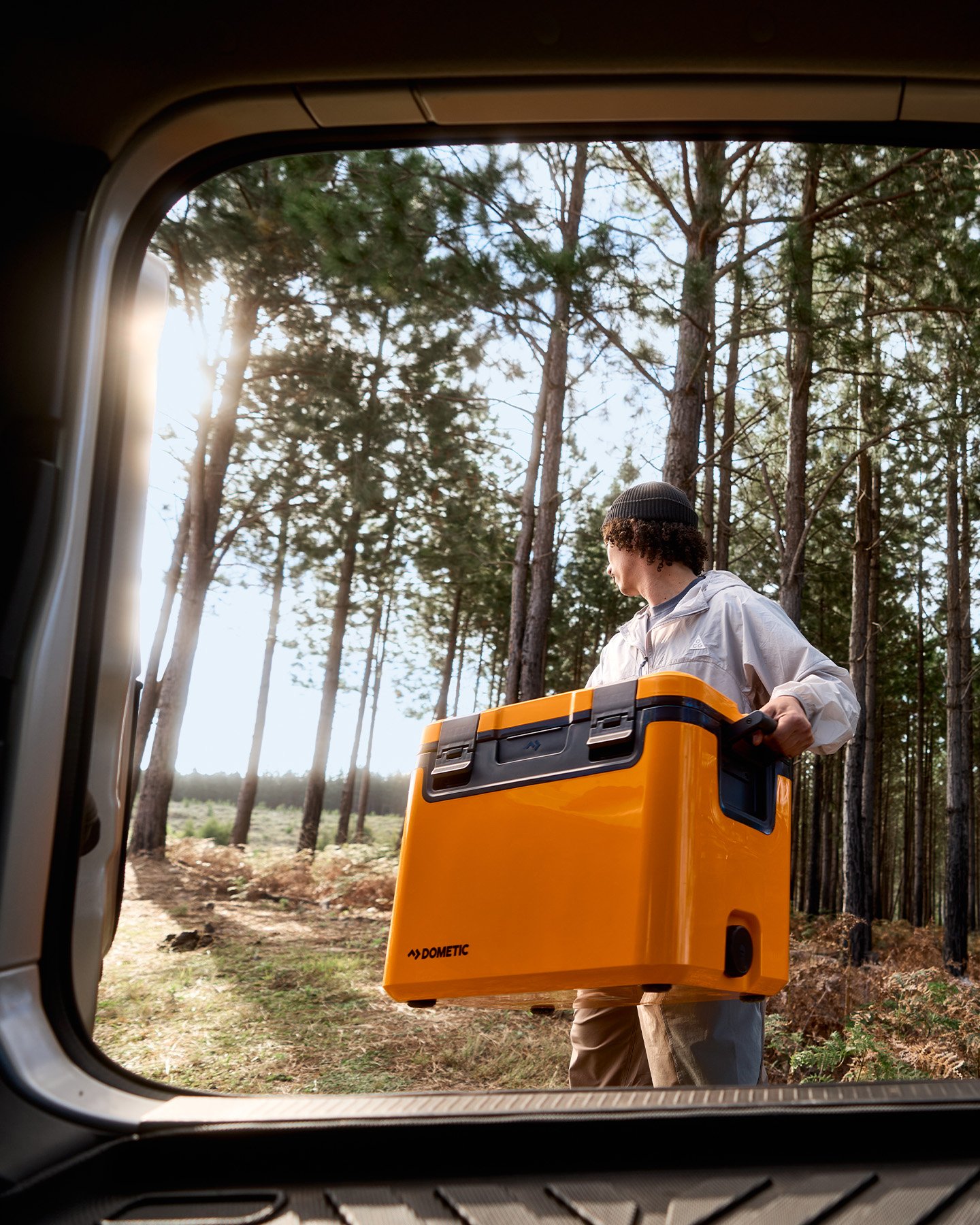 Dometic Recon passiv kylbox i orange bärs från fordon i skog, slitstark hard cooler för camping och outdoorbruk