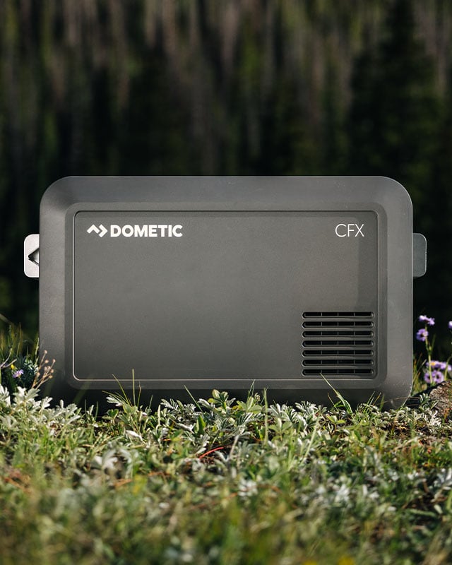 Dometic CFX5 Kompressor-Kühlbox auf Gras im Freien platziert, tragbare elektrische Kühlbox für Camping, Roadtrips und Outdoor-Abenteuer