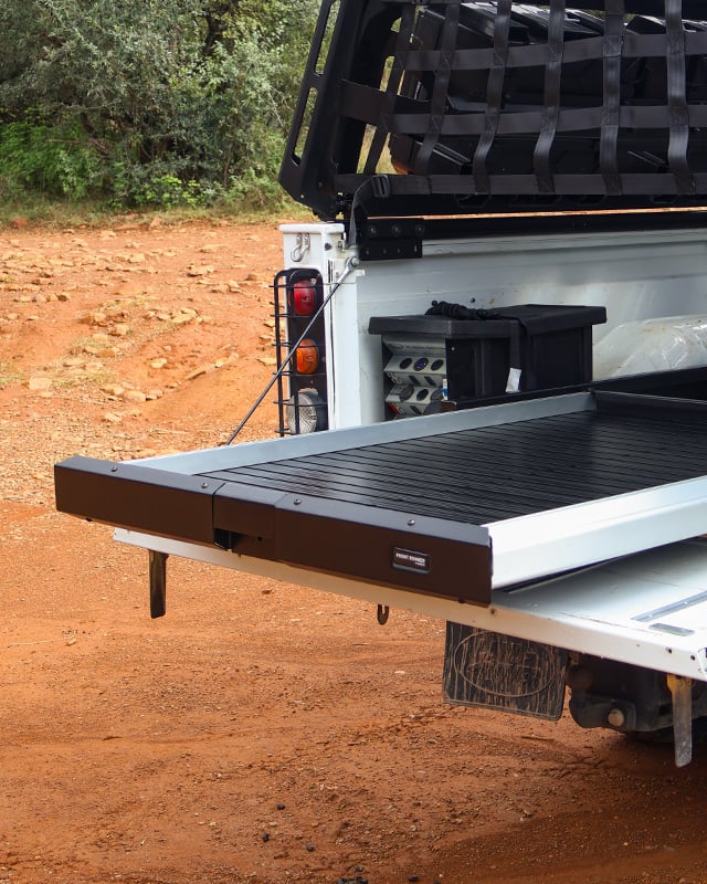 white bakkie with a cargo bed slide in desert