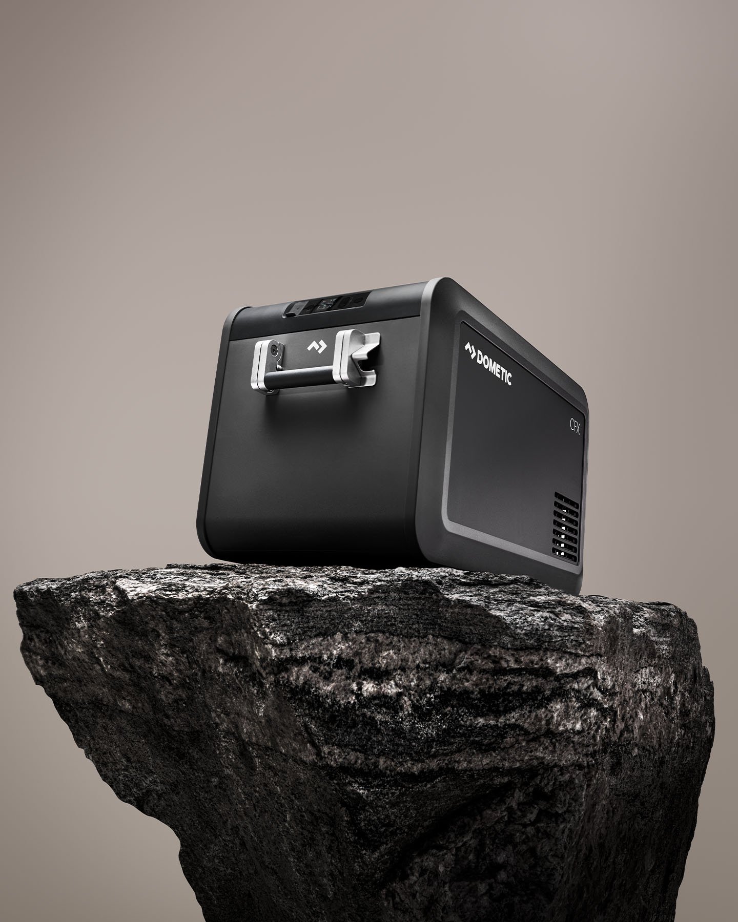 Dometic CFX5 kompressorkylbox placerad på en klippa, portabel elektrisk kylbox för camping, bilresor och outdooräventyr