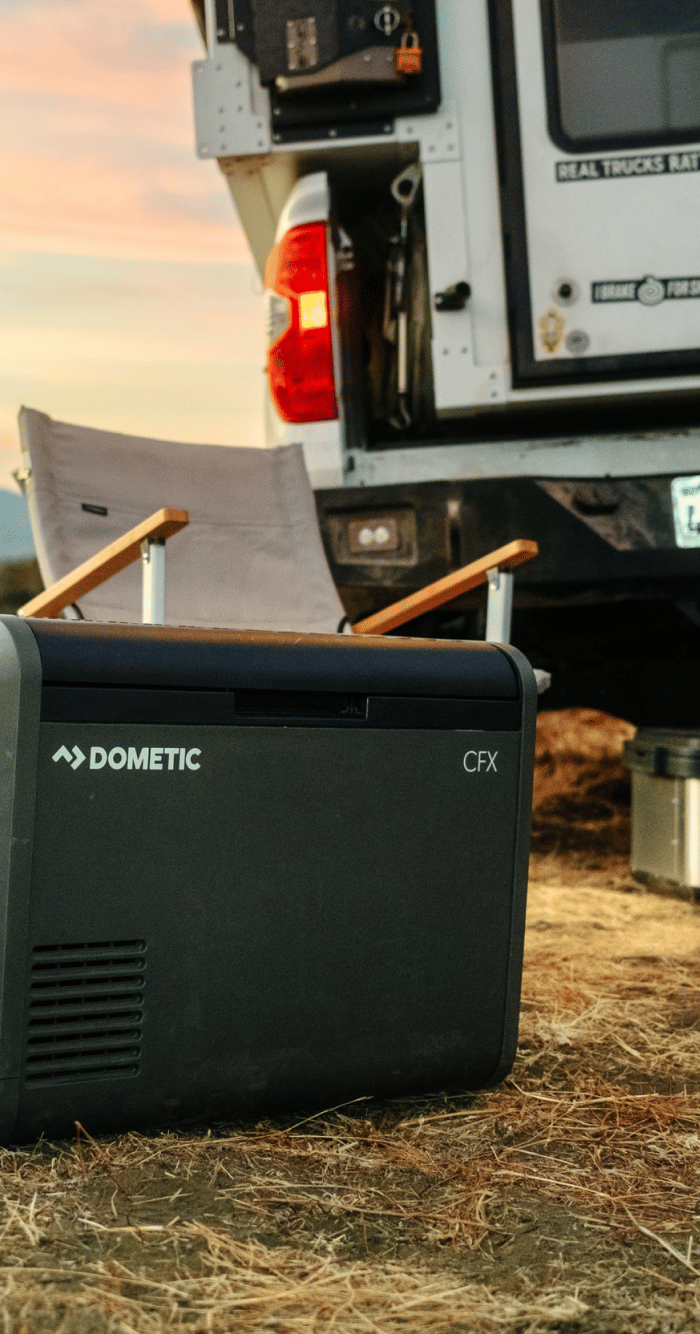 CFX Electric cooler in front of campsite at sunset.