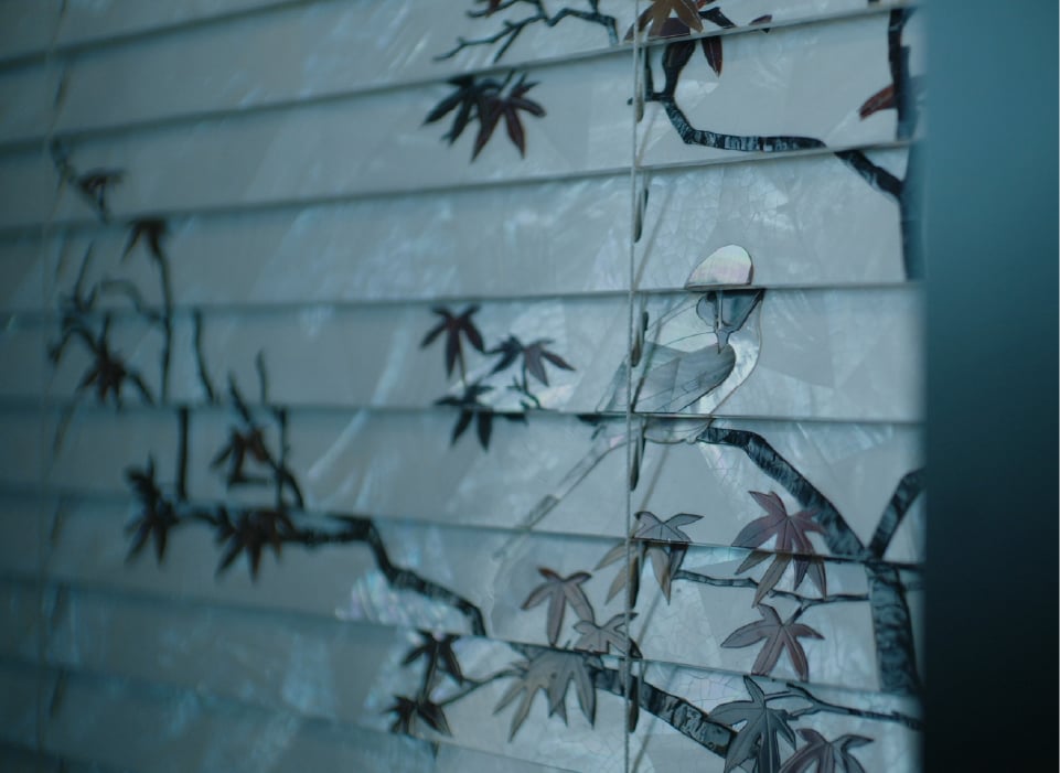 Detail shot of blinds patterned with branches and leaves