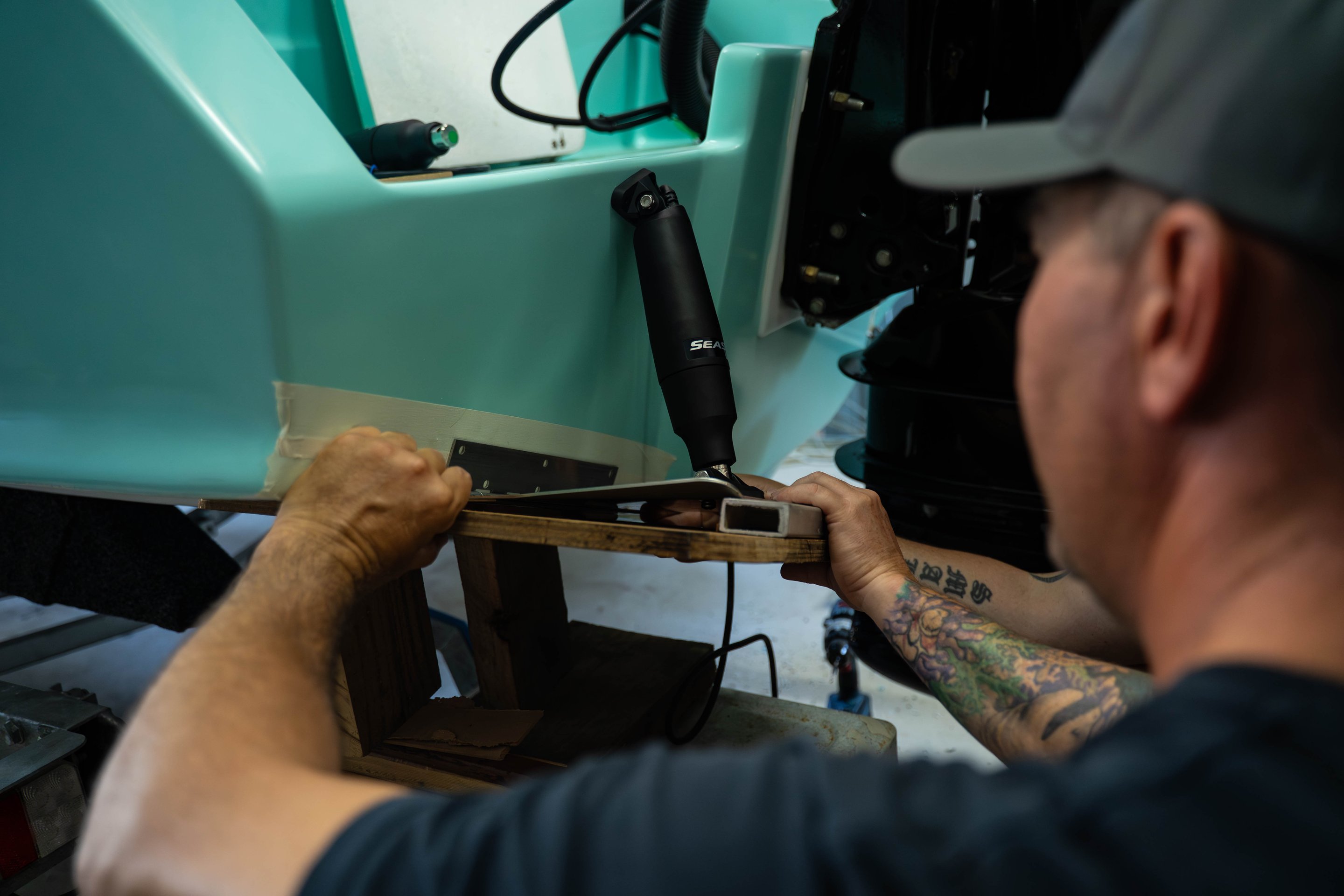 Person installing trim tabs on a boat