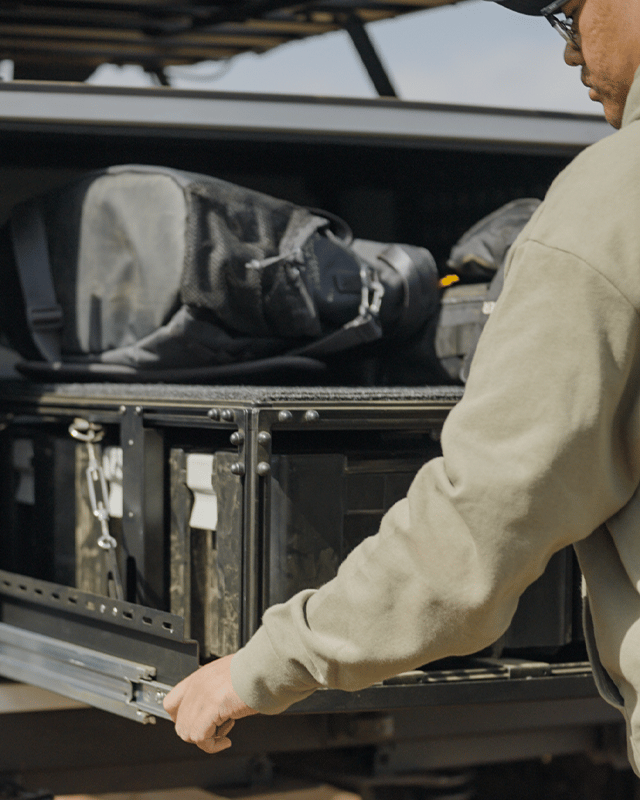 Man pulling out drawer system out of bed of truck