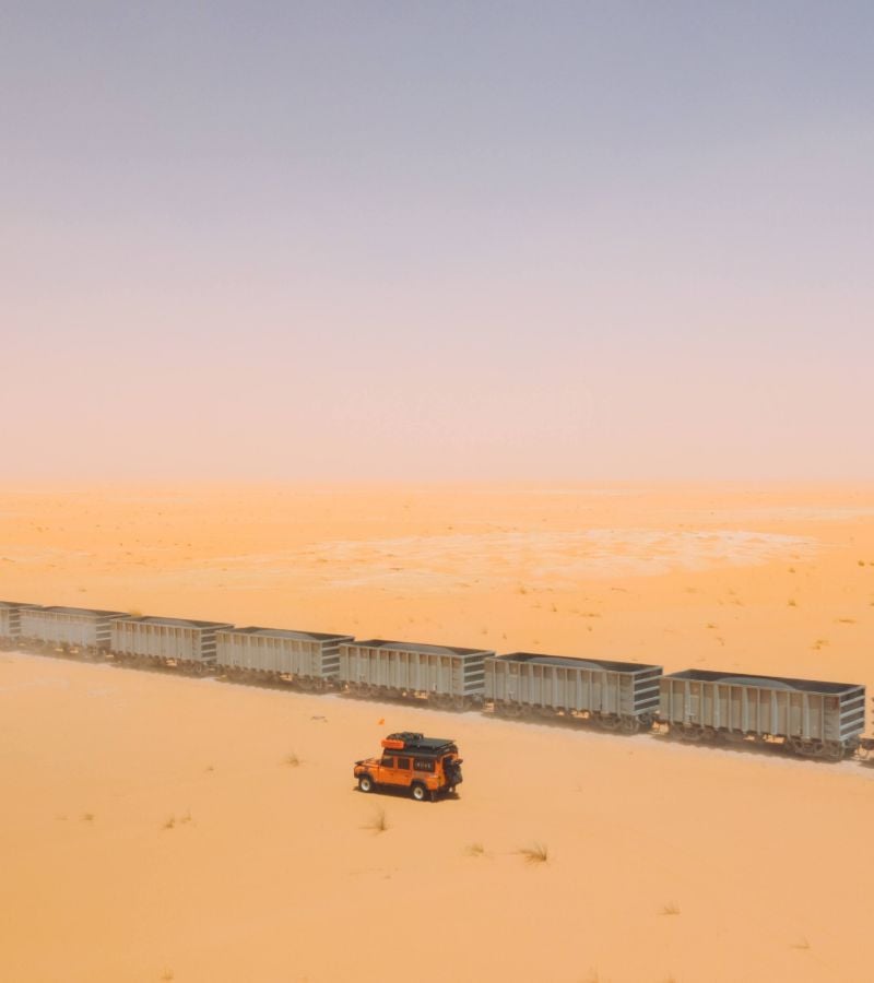 Drone shot of vehicle driving with sunset sky