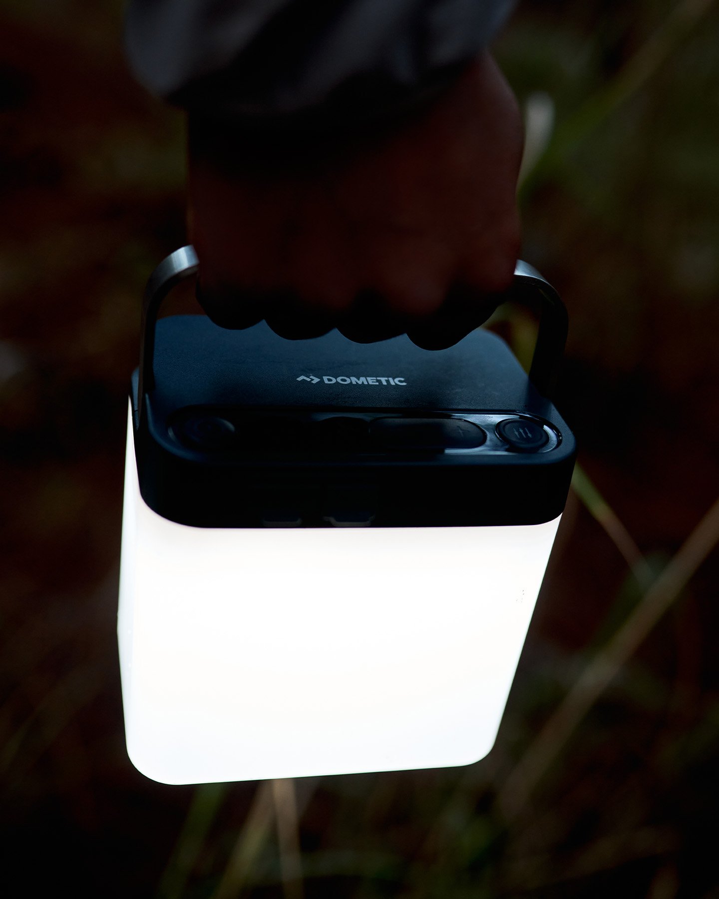 Dometic GO Area Camp Light buren i hand på kvällen, portabel utomhuslampa för belysning vid camping och overlandresor