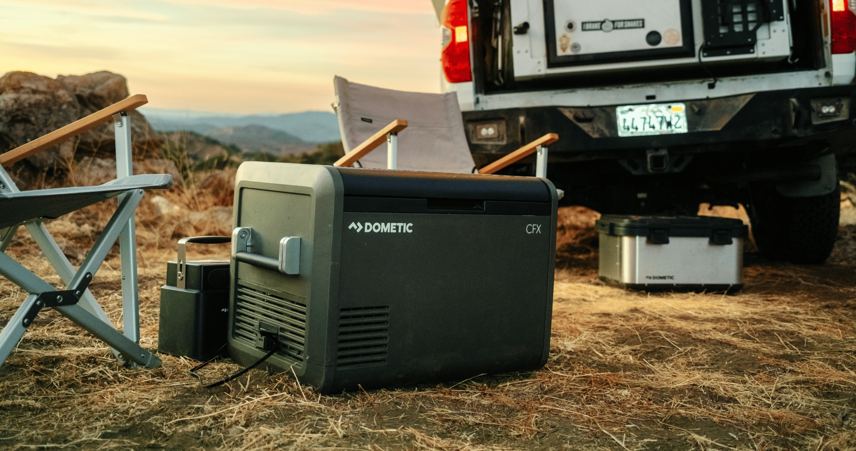 CFX Electric cooler in front of campsite at sunset.