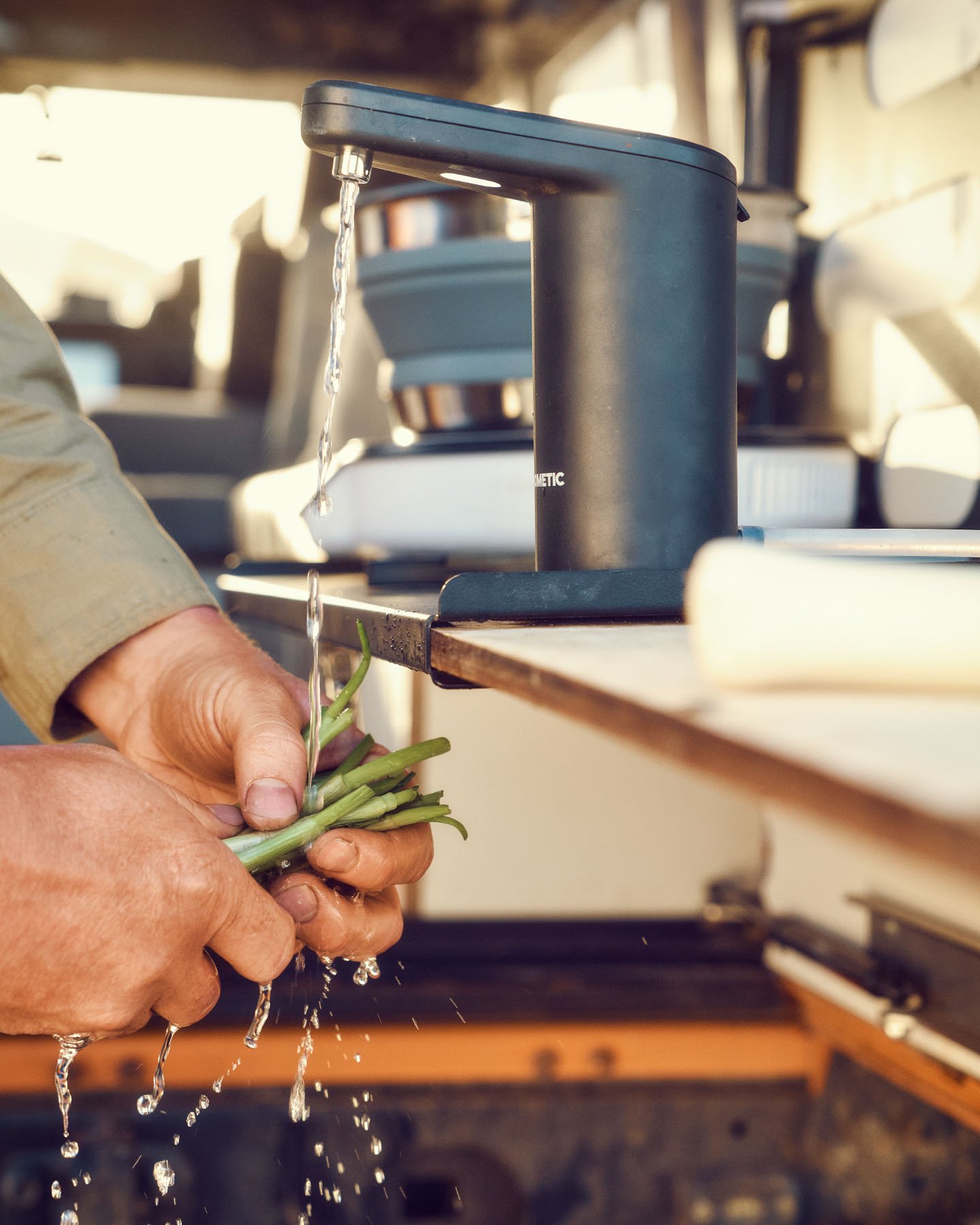 person washing plants under dometic jug tap