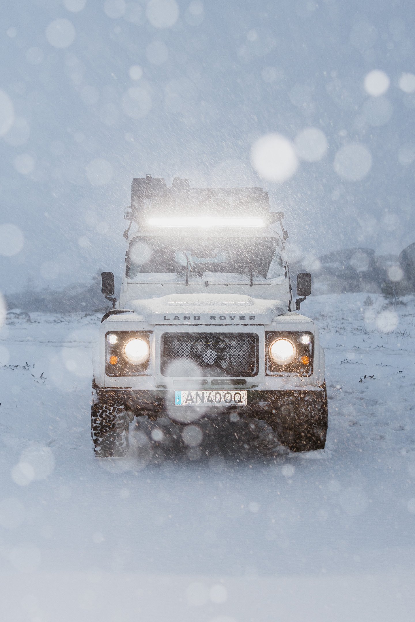 Terreinwagen in hevige sneeuw met een felle LED-lichtbalk, die uitstekende zichtbaarheid en duurzaamheid in de winter biedt.