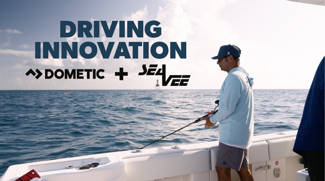 A person in a blue shirt and baseball cap fishing off the side of a boat