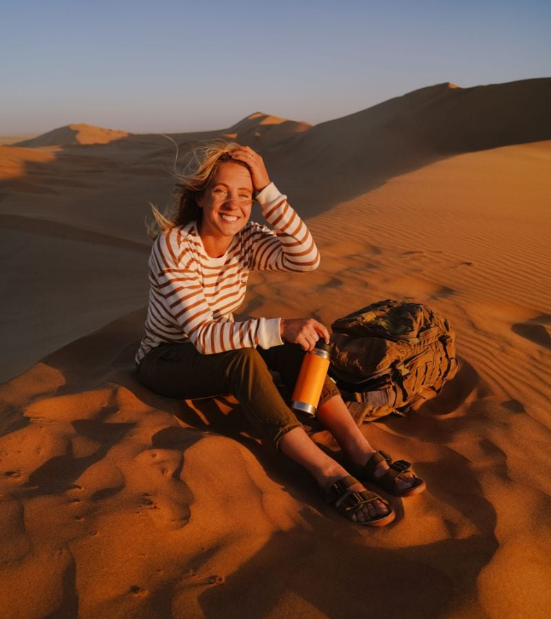 Woman sitting on desert sand dune