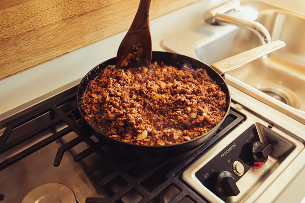  A close up of ground beef on a Dometic stove top.