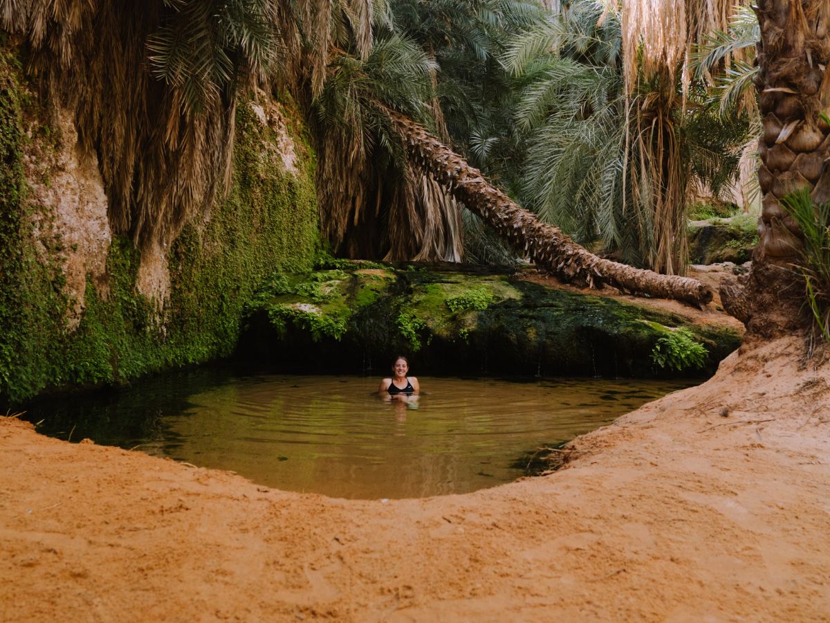 Person sitting in lake surrounded by nature