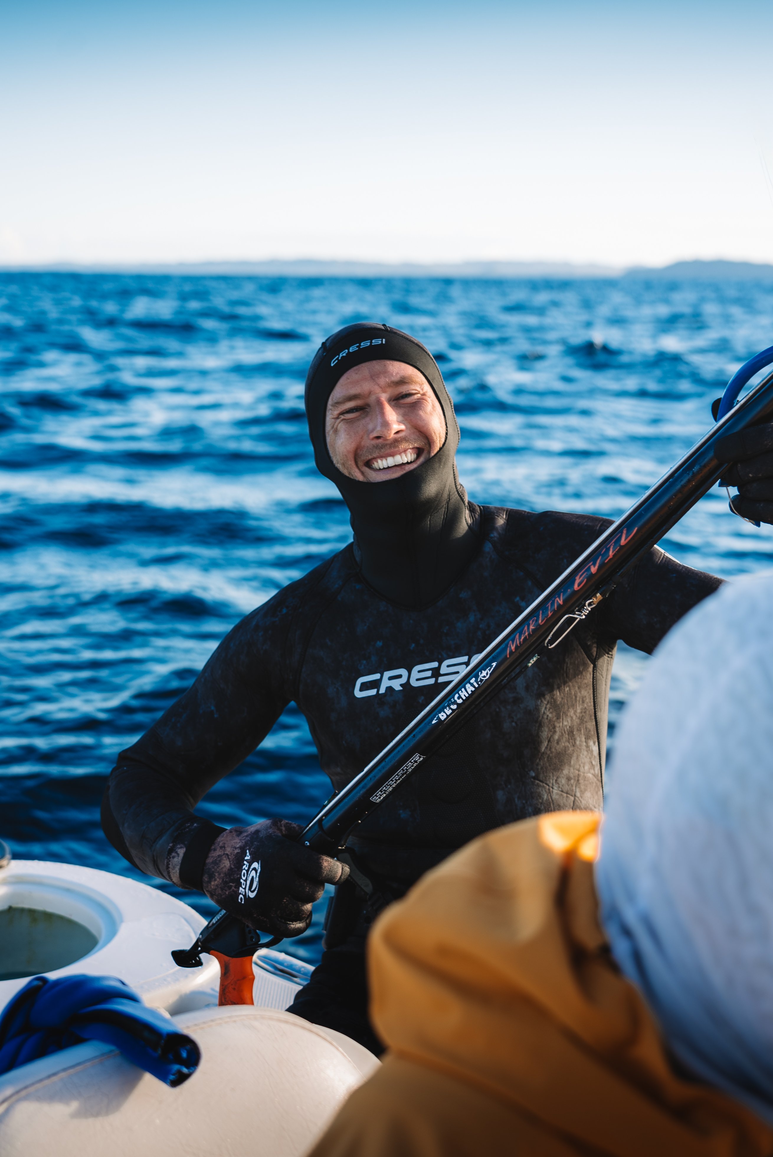 Person in wetsuit smiling on the water