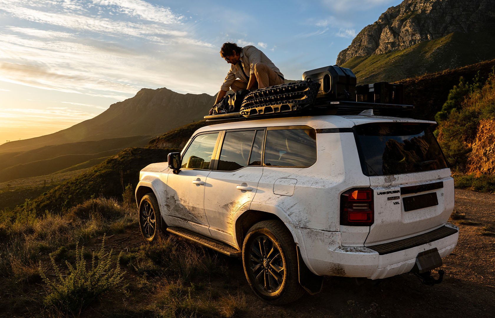 Slimline 3 roof rack loaded with recovery boards, storage gear and adventure equipment on a vehicle parked in a mountain landscape