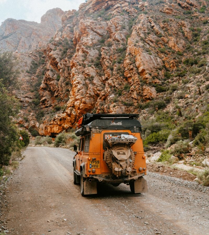 Back of vehicle driving on gravel road