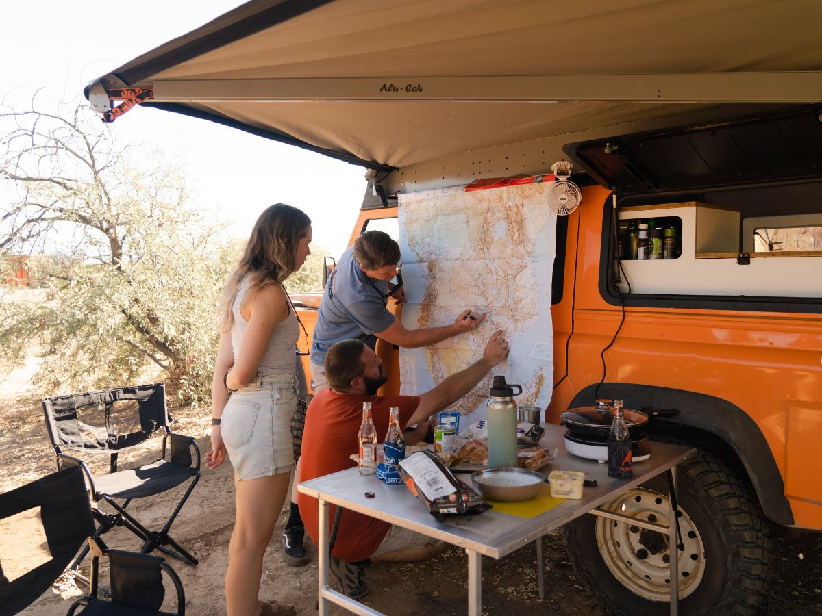 Two people looking at map on car planning their roadtrip route