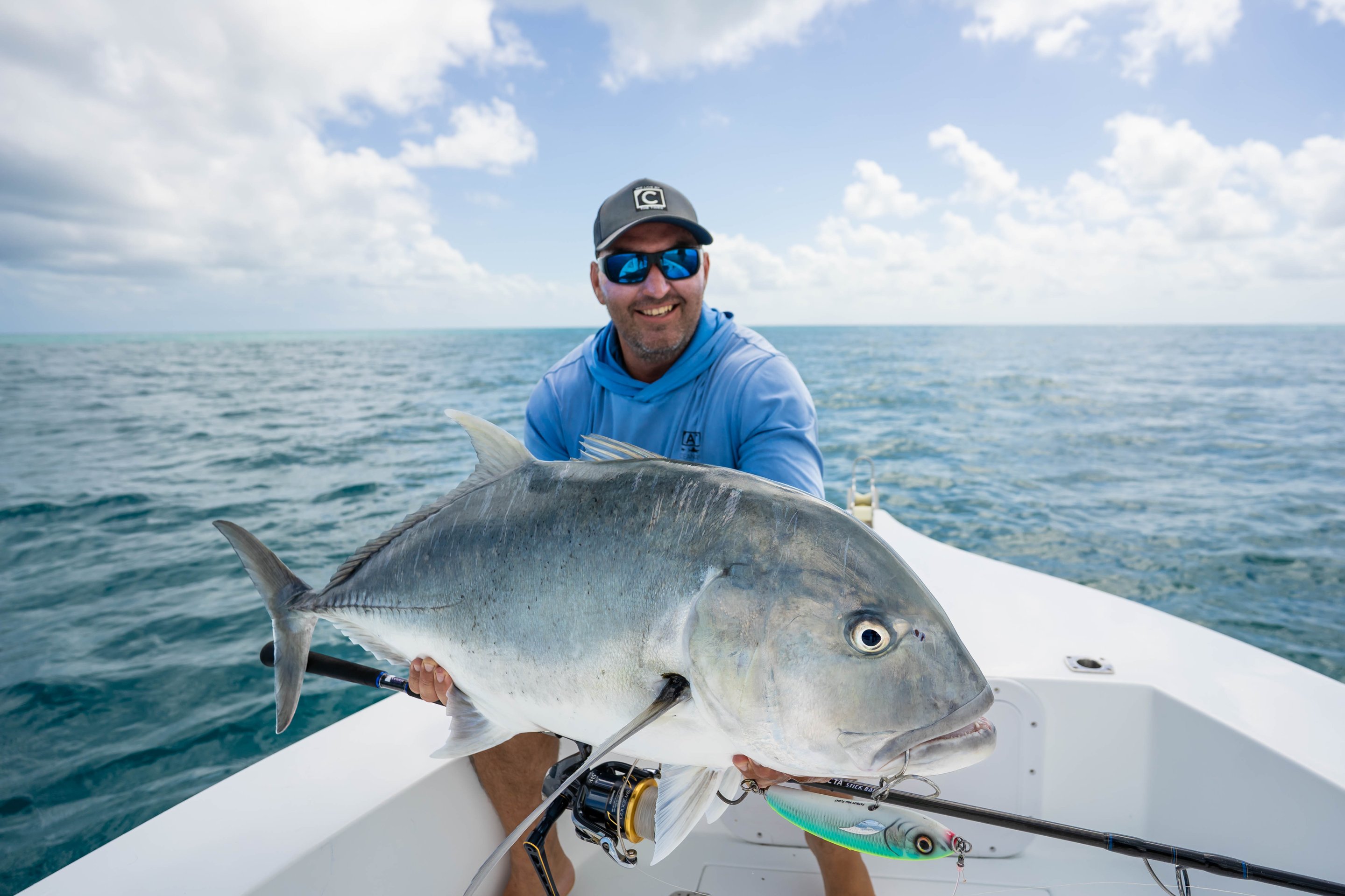 Person sitting on boat holding large fish