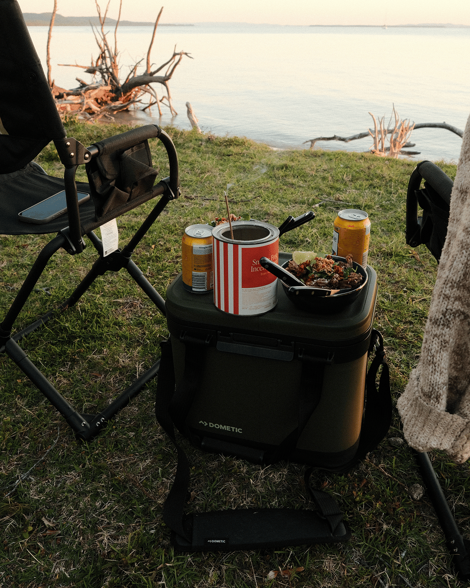 Breanne soaks up the spectacular waterfront sunset from her camp with a few snacks in her Dometic Recon Softside on North Stradbroke Island.