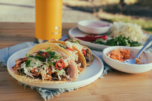 A close up of tacos and a Dometic water bottle.