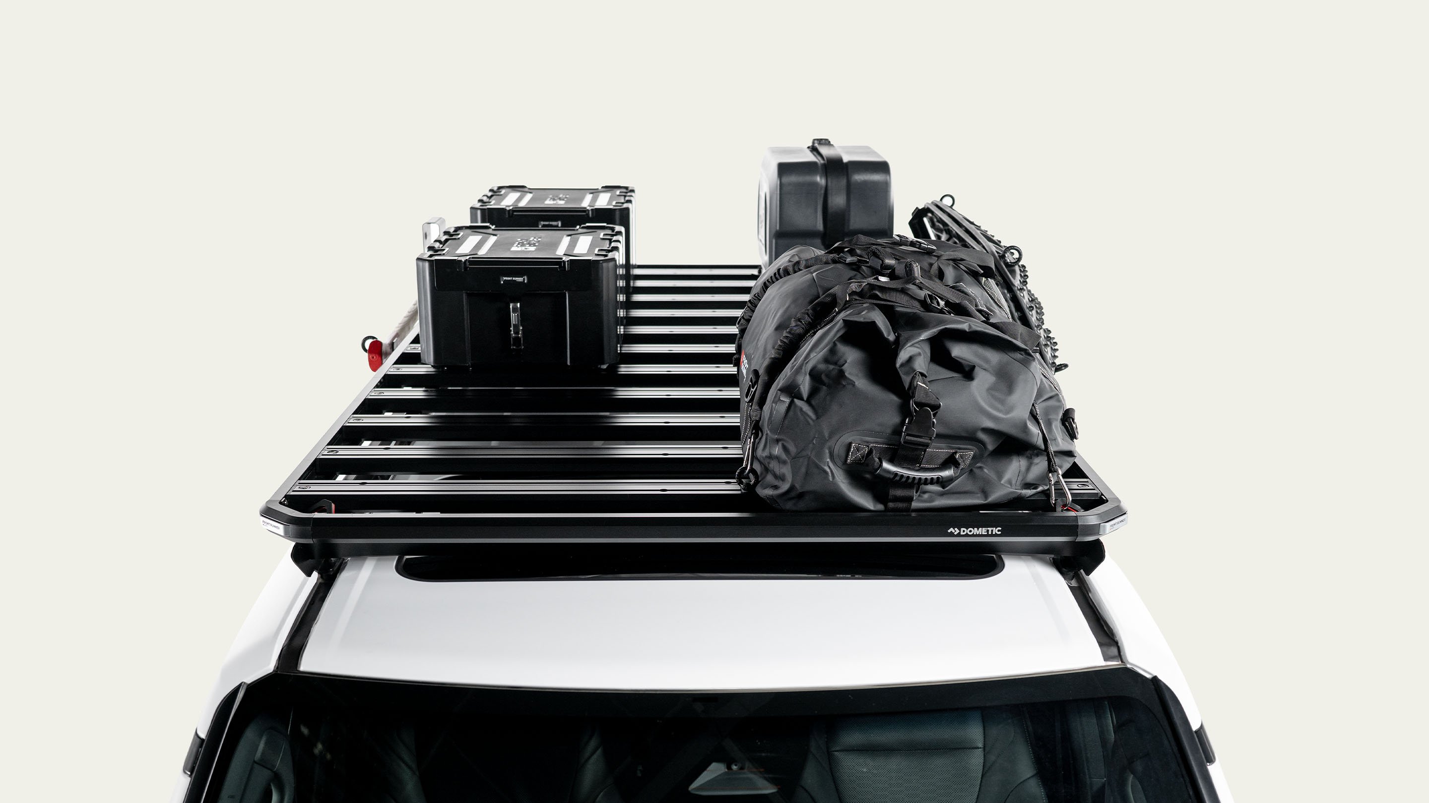 Dometic Front Runner Series Slimline 3 roof rack loaded with storage boxes, jerry can and gear bag, modular cargo platform for overland travel
