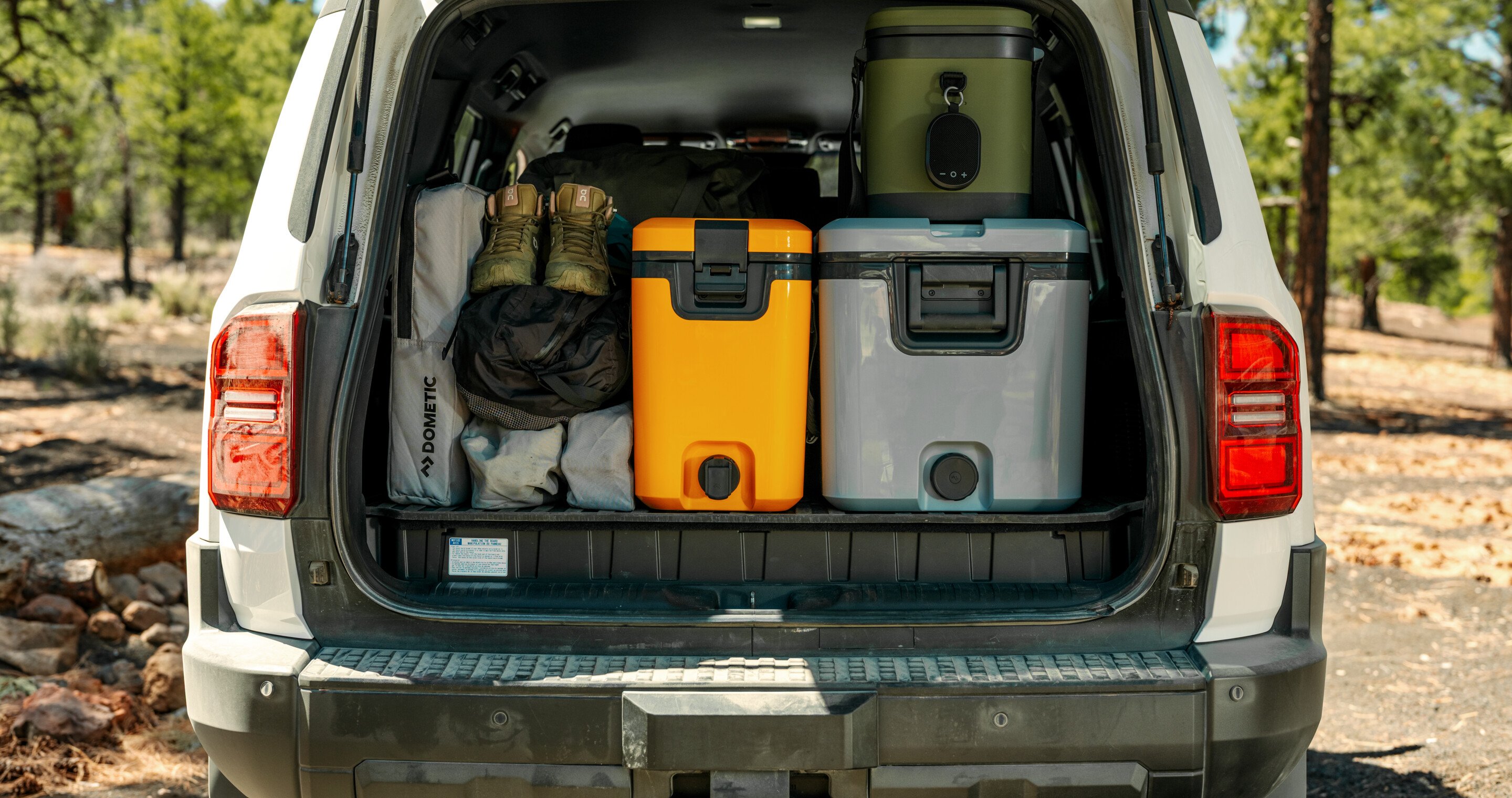 Recon coolers stacked in the back of an SUV ready for camping trip