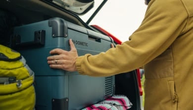 Man lastar en elektrisk Dometic kylbox i bilens bagageutrymme