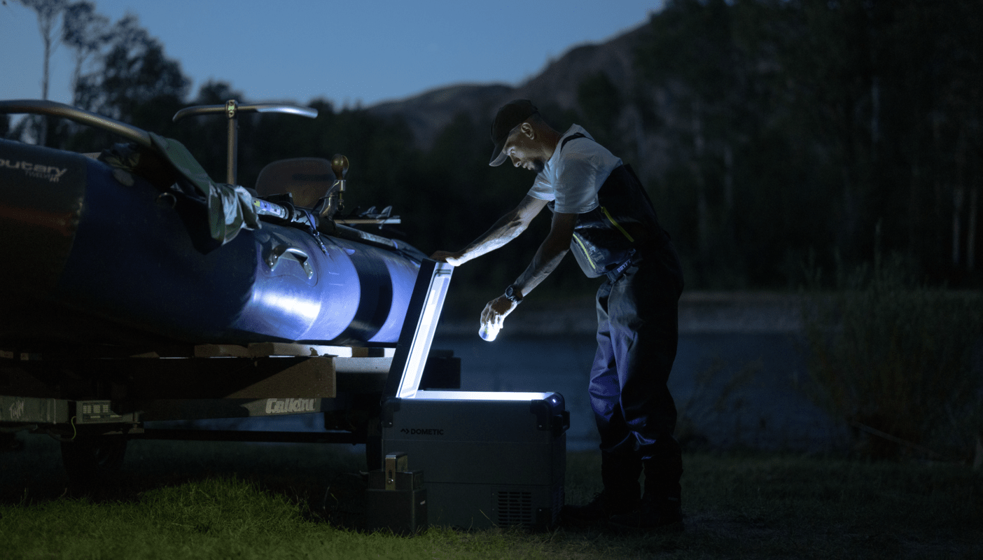 Man öppnar en elektrisk kylbox i mörkret