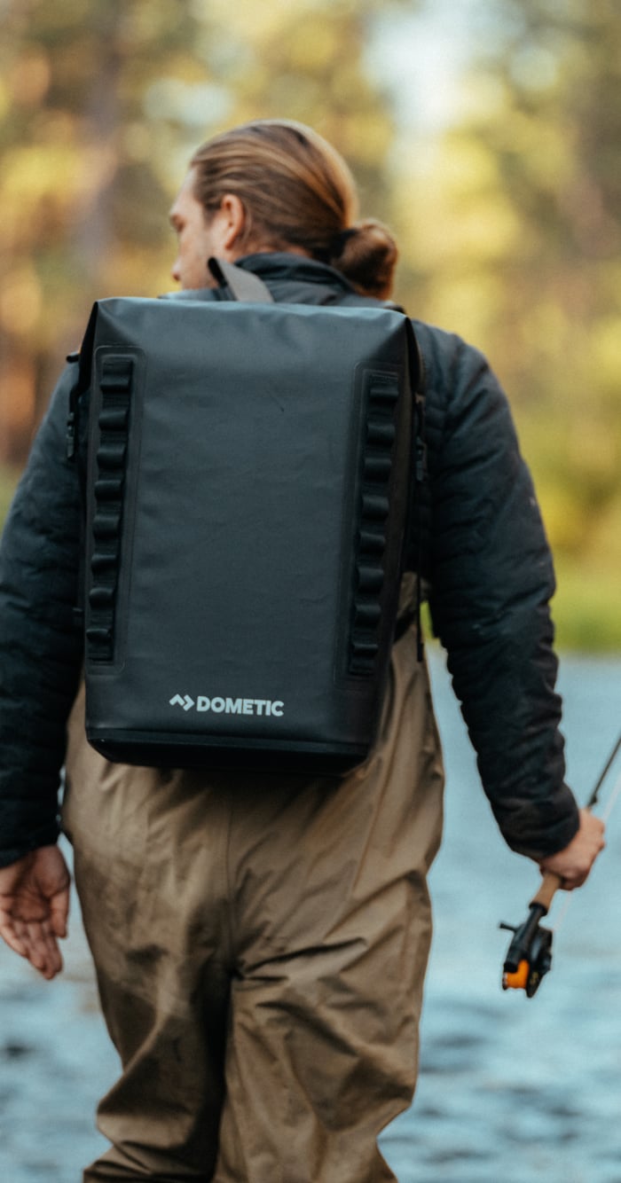 Homme pêchant avec une glacière souple PSC Dometic.