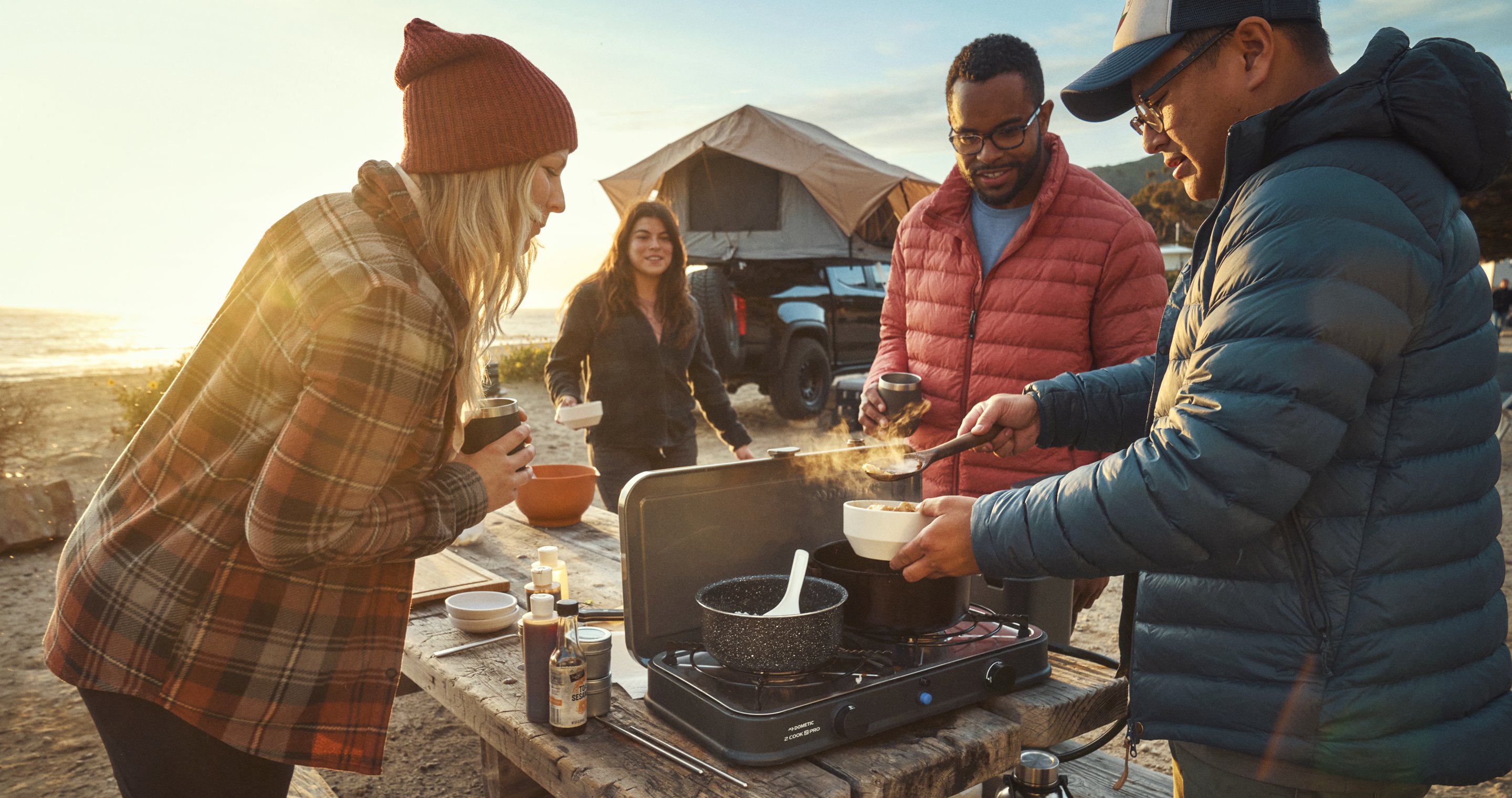Family cooking outdoors with Dometic Water Jug