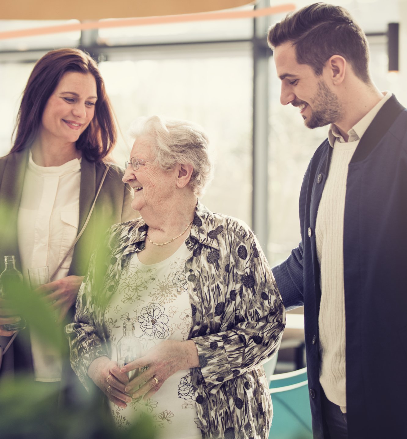 Elderly lady enjoying the company of a man and a woman.