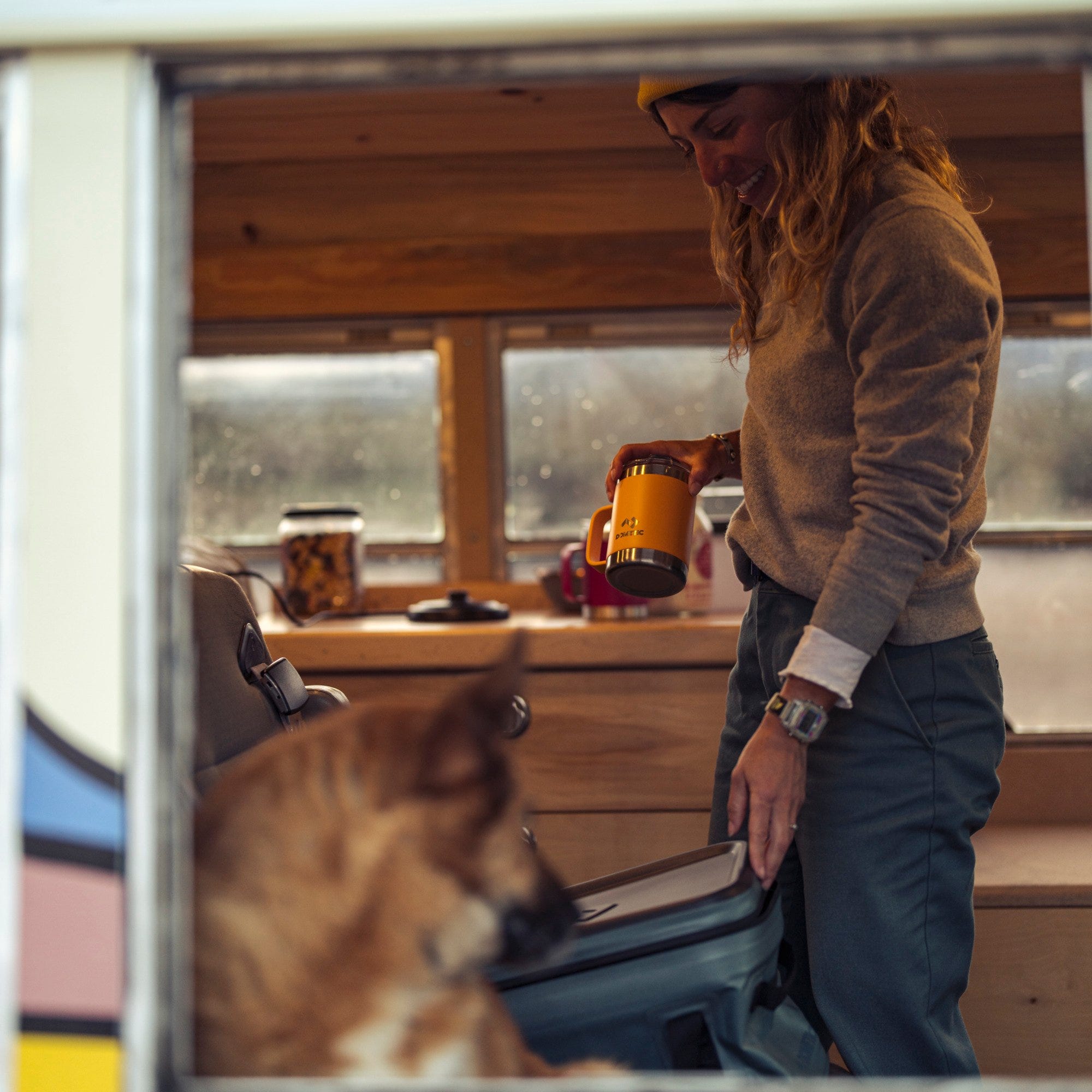 woman pulling cup out of soft storage while camping