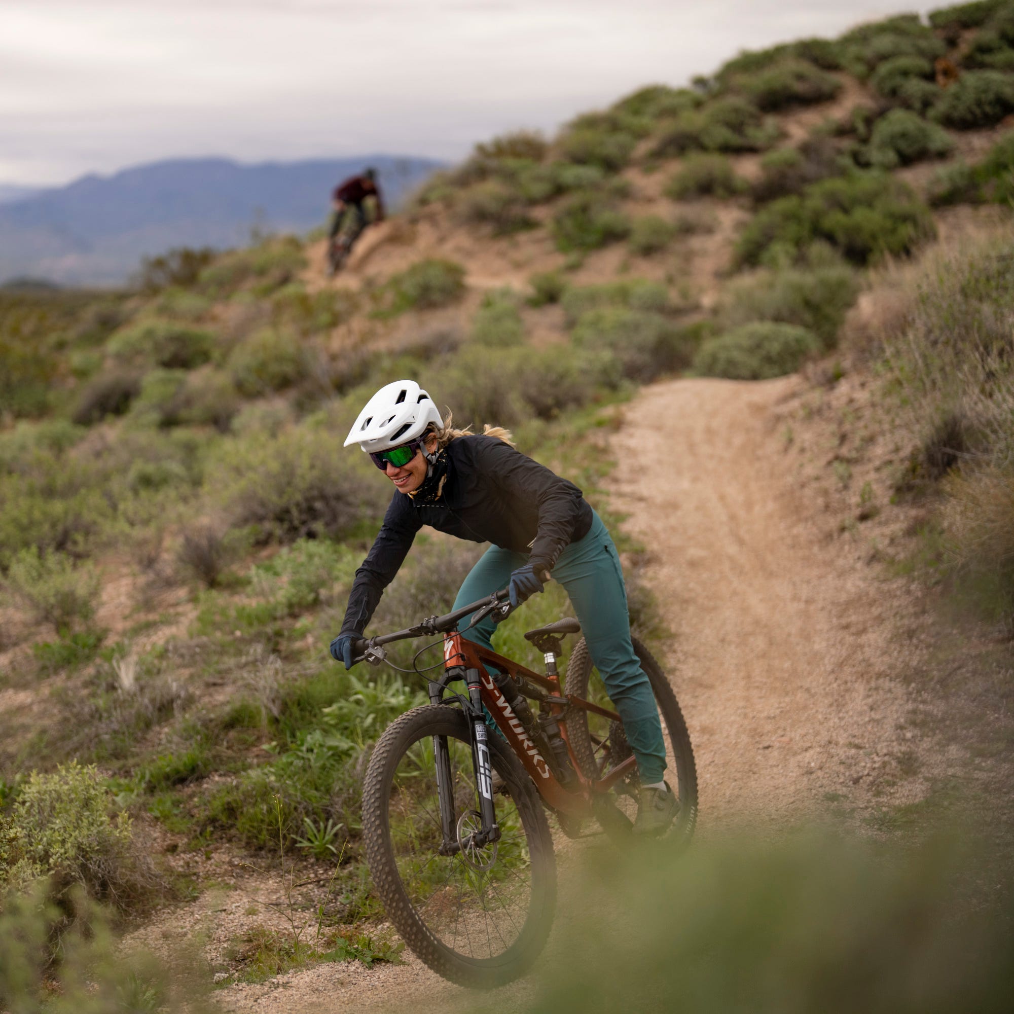 woman mountain biking on trail