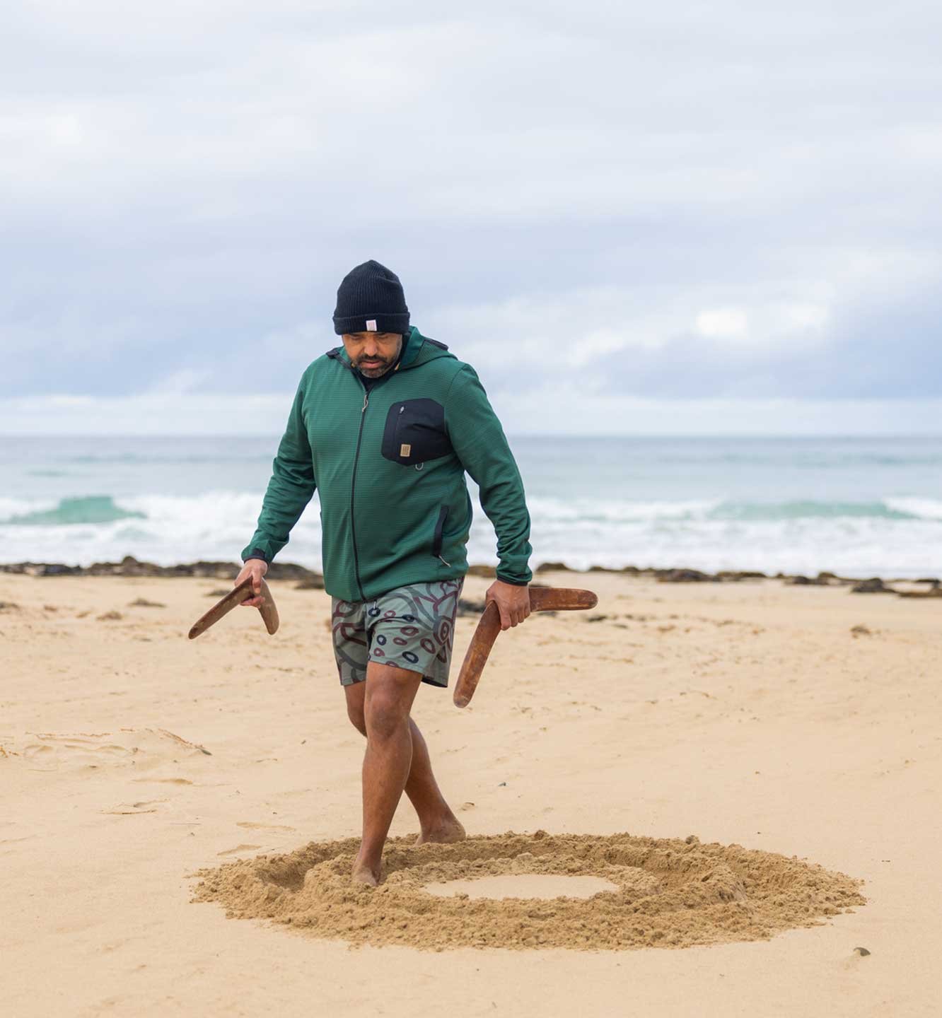 Lowell Hunter tracing patterns in the sand
